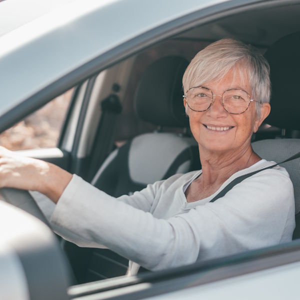 senior-woman-smiling-while-driving-car-600x600.jpg